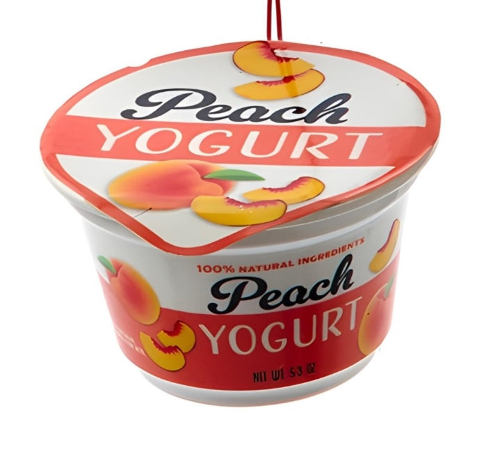 Ornament shaped like a cup of yogurt. One ornament is white and red and "flavored" strawberry. One ornament is white and blue and "flavored" blueberry. One ornament is white and orange and "flavored" peach. One ornament is white and blue and "flavored" Greek-style.