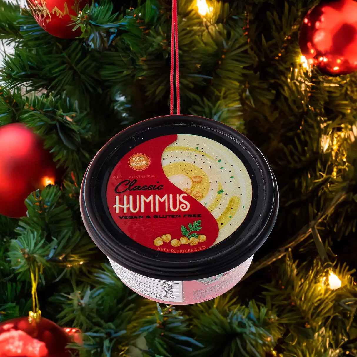 Plastic ornaments shaped like different party dips. One is a red container that reads "Classic Hummus." One is a green container that reads "French Onion Sour Cream Dip." One is a blue container that reads "Cream Cheese Spread."