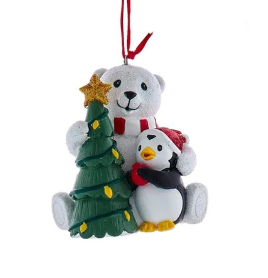 One ornament features a polar bear and a penguin decorating a Christmas tree. Hangs from a red ribbon.