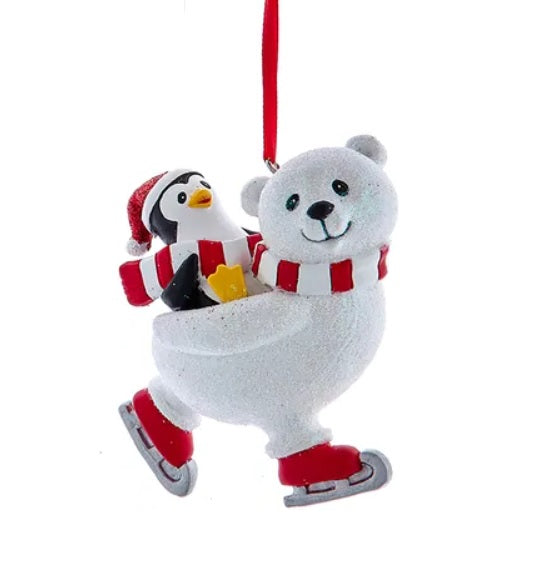 One ornament features a polar bear ice skating with a penguin on its back. Hangs from a red ribbon.