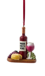 Ornament shaped like a plate with wine and cheese. One ornament features a bottle of red wine that reads "Working nine to wine." One ornament features a green bottle that reads "Partners in Wine." Each ornament features red and green grapes, wine glasses and some cheese.