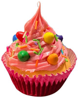 Christmas ornaments shaped like cupcakes with different colored frosting and candies on them.