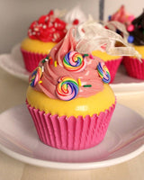 Christmas ornaments shaped like cupcakes with different colored frosting and candies on them.