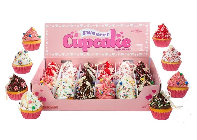 Christmas ornaments shaped like cupcakes with different colored frosting and candies on them.