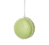 Ornaments shaped like a macaron cookie. One is pink, one is blue and one is green. They're all decorated with glitter to appear covered in sugar.