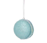 Ornaments shaped like a macaron cookie. One is pink, one is blue and one is green. They're all decorated with glitter to appear covered in sugar.
