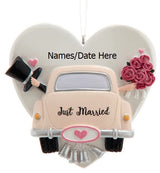 Ornament shaped like a heart with a car in front of it. Also features a top hat, delicate flowers and tin cans trailing behind. Can be personalized.
