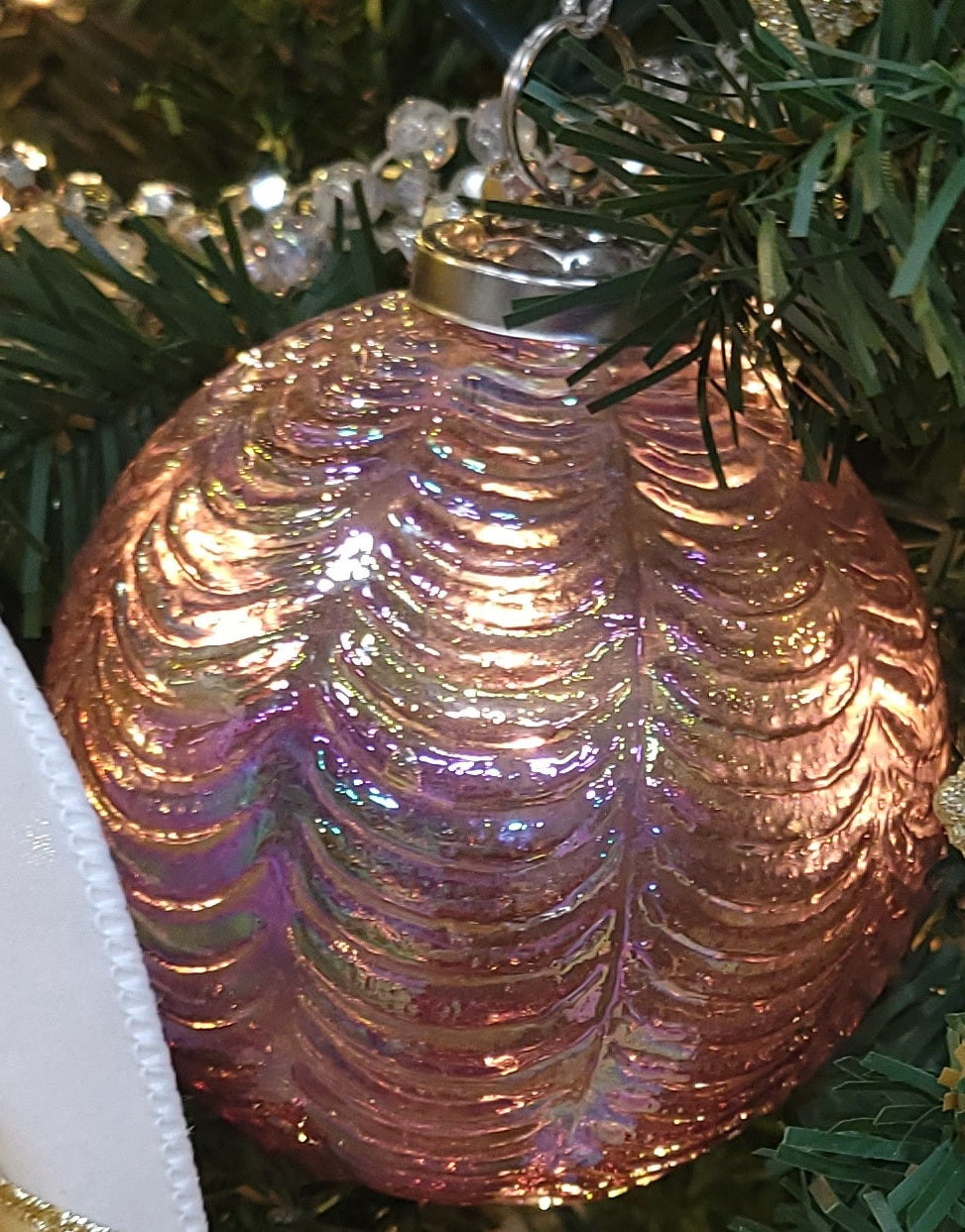 This image shows the ornament hanging in a green Christmas tree.
