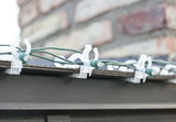 This is a lifestyle image showing the light clips holding a string of lights on the edge of a roof.