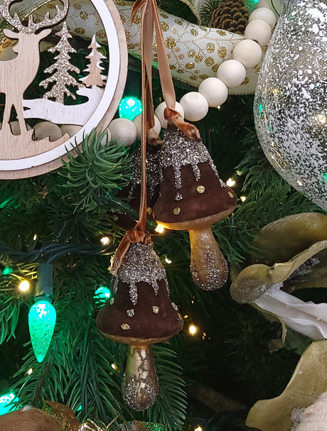 Ornament featuring three mushrooms covered in felt and glitter. Colors are Acorn Brown, Gold and Silver.