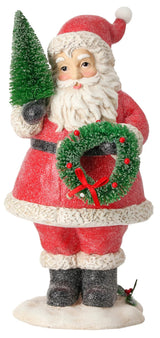 Ornament shaped like Santa Claus holding a small tree and a small, decorated wreath.