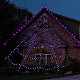 A large light up web Halloween decoration with a large fake spider in it with red eyes. The colors change from purple to orange. Perfect for outdoor decorating.