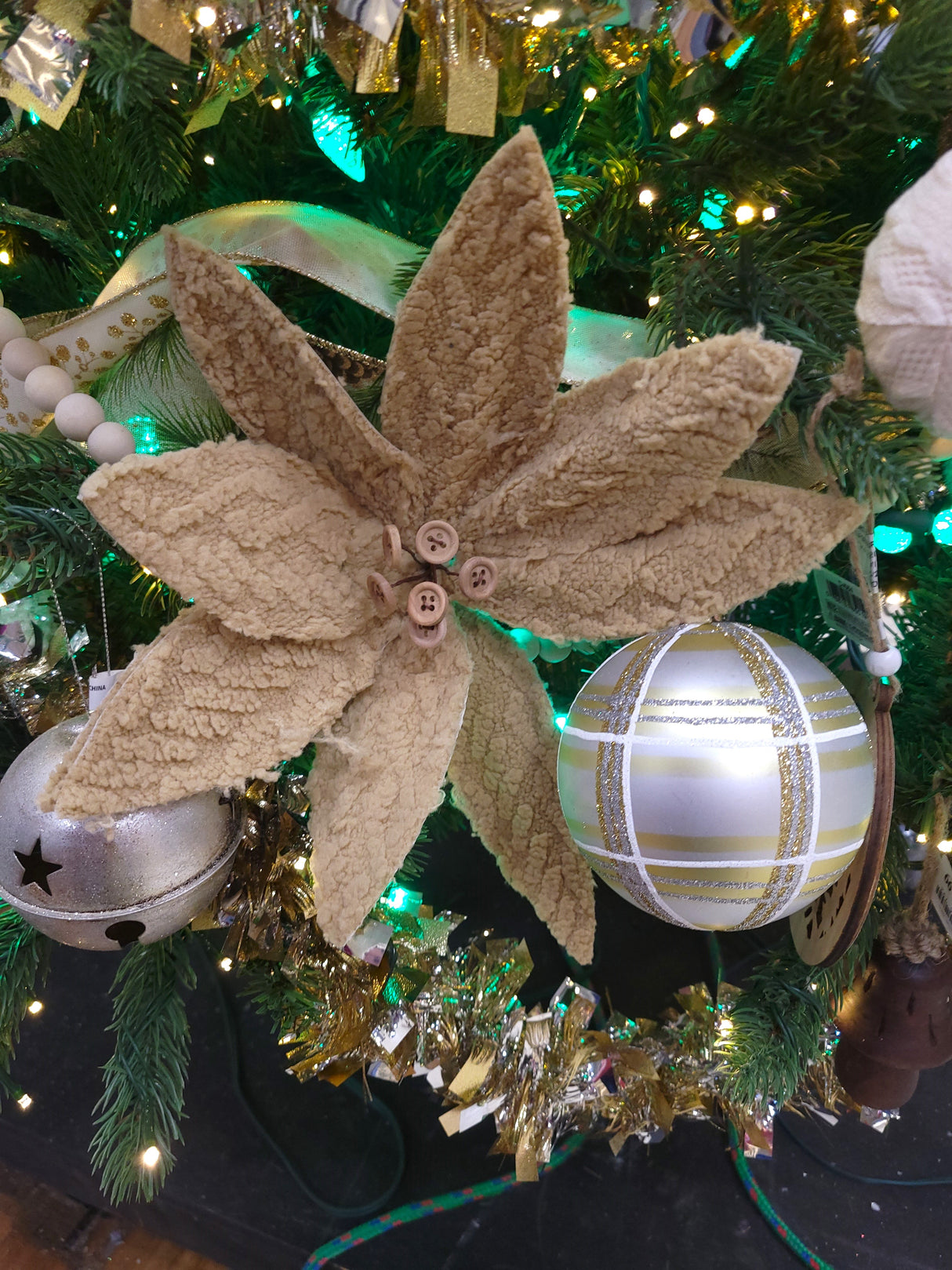 Tan colored pick spray designed to look like a poinsettia with tan colored buttons in the center.
