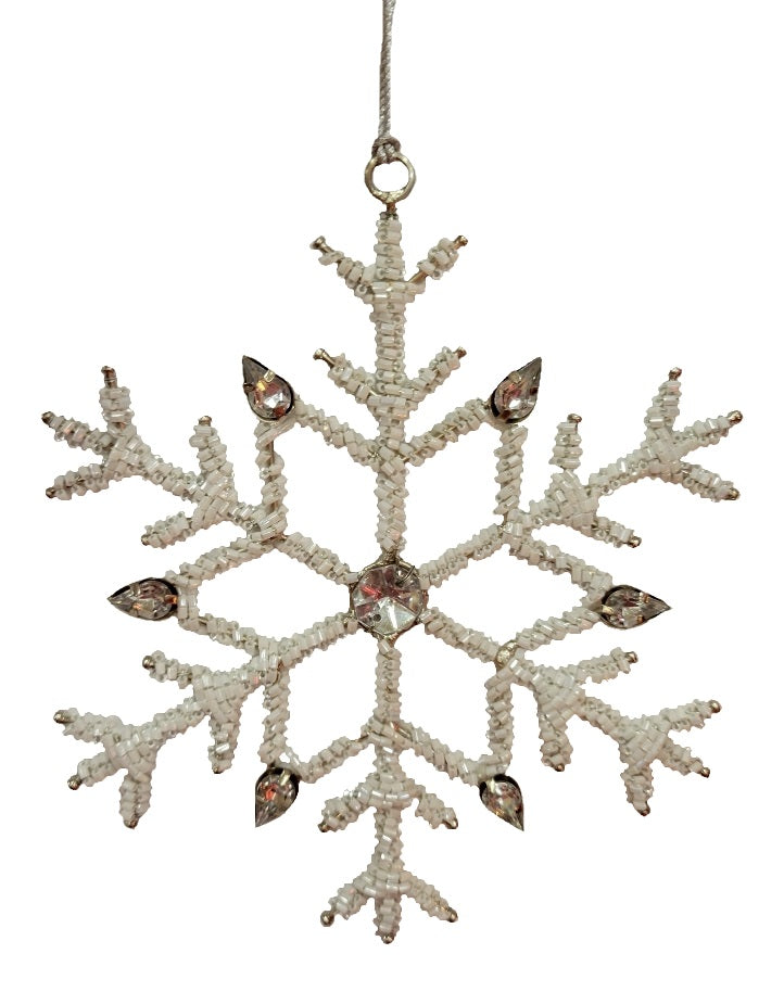 Ornament shaped like a snowflake and decorated with white beads and silver jewel accents.