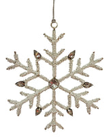 Ornament shaped like a snowflake and decorated with white beads and silver jewel accents.