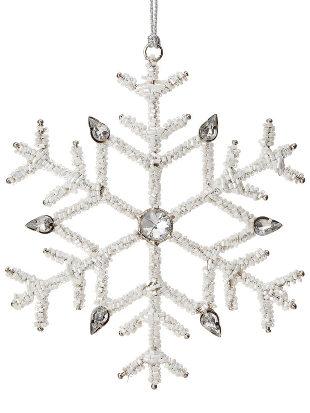 Ornament shaped like a snowflake and decorated with white beads and silver jewel accents.