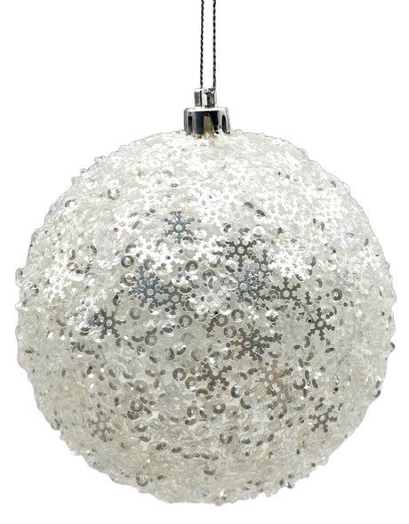 Round ornament decorated with metallic, white snowflake sequins.