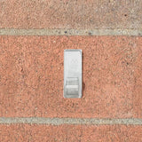 This is a lifestyle image showing the clip stuck to a brick.