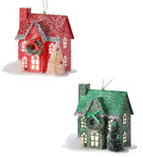 Ornament shaped like a house covered in snow. One house is red and features a wreath near the roof with a red bow. One house is green and features a wreath near the roof with a green bow.