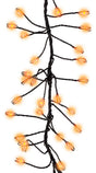 This image shows an up close view of the orange big seed cluster light string.