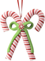 An ornament shaped like two red, white and pink candy canes tied together with a green bow.