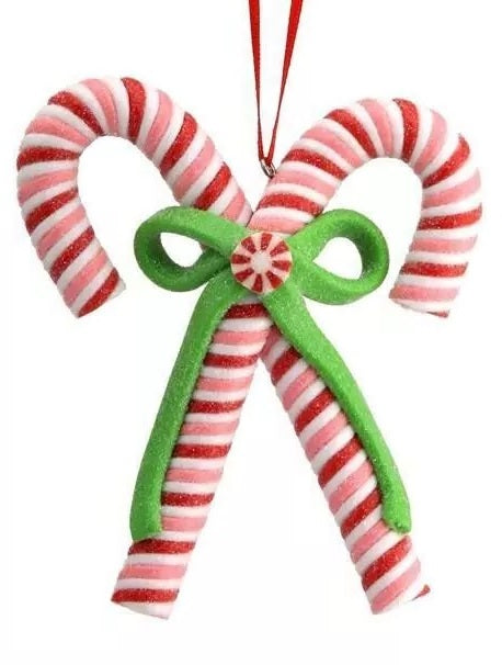An ornament shaped like two red, white and pink candy canes tied together with a green bow.