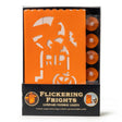 Set of orange flame-resistant luminary bags with cut-out designs on them. These bags are designed to have a light inside them so you can see the cut-out design lit up. This is an image showing the bags and the tealights in the packaging. It reads "Flickering Frights Luminary Pathway Lights. Contains 6 paper lantern bags and 6 battery operated tealight candles."