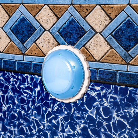 This is a lifestyle image showing the light plugged into the return jet on the side of a pool.