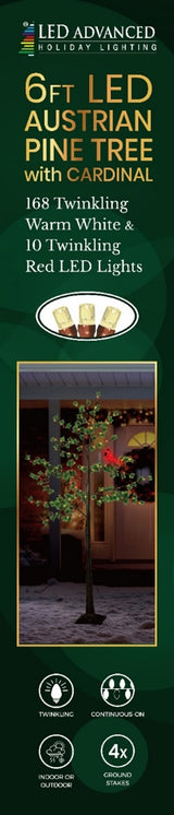 Pre-lit fake Christmas pine tree. Lights are warm white and red and the leaves are green. There's also a lit cardinal attached to one of the branches.