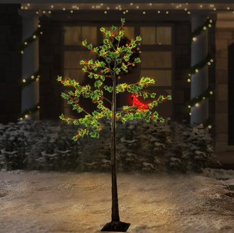 Pre-lit fake Christmas pine tree. Lights are warm white and red and the leaves are green. There's also a lit cardinal attached to one of the branches.