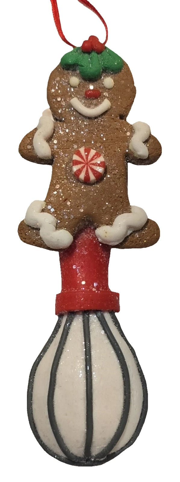 This image shows the gingerbread man wearing holly leaves and berries on his head and features frosting sleeves and frosting pant cuffs. It also features a whisk.