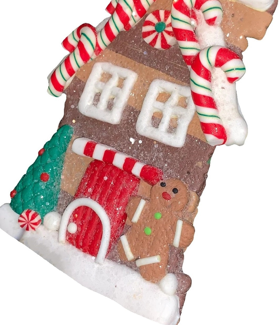 This ornament was designed to look like a gingerbread cookie house covered in sugar. This specific ornament has small red, green and white candy canes on the roof and features a tree on the left side of the front door and a gingerbread man on the right side.