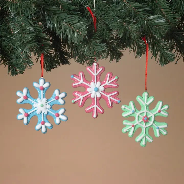This is a lifestyle image showing the three different ornaments hanging from a tree branch.