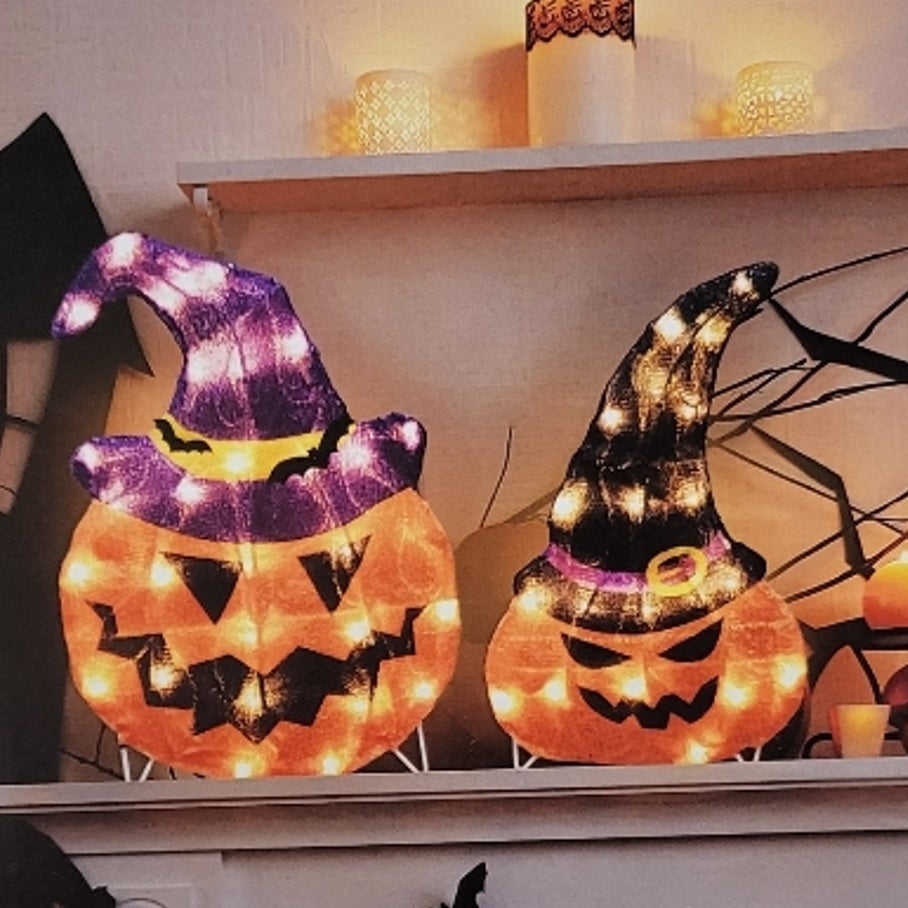 Set of 2 lighted jack-o-lantern decorations. One is wearing a purple witch hat with bats on it. The other is wearing a black witch hat.