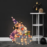 Lighted Halloween decoration. Looks like Lucy and Snoopy from the Peanuts cartoons bobbing for apples. Lucy is dressed in a pointed, purple hat and dress. Snoopy appears to be dressed as a pilot. Snoopy is inside the small water tub.