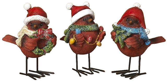 Standing red cardinal decoration for Christmas. One cardinal is wearing a white scarf and holding a wreath. One cardinal is wearing a green scarf and holding a string of lights. One cardinal is wearing a blue scarf and holding a small tree.