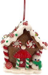 Ornaments shaped like gingerbread houses decorated with sugar, frosting, peppermint candies, gummy candies and candy canes. This one features a red and white swirled candy and a snowman accent.