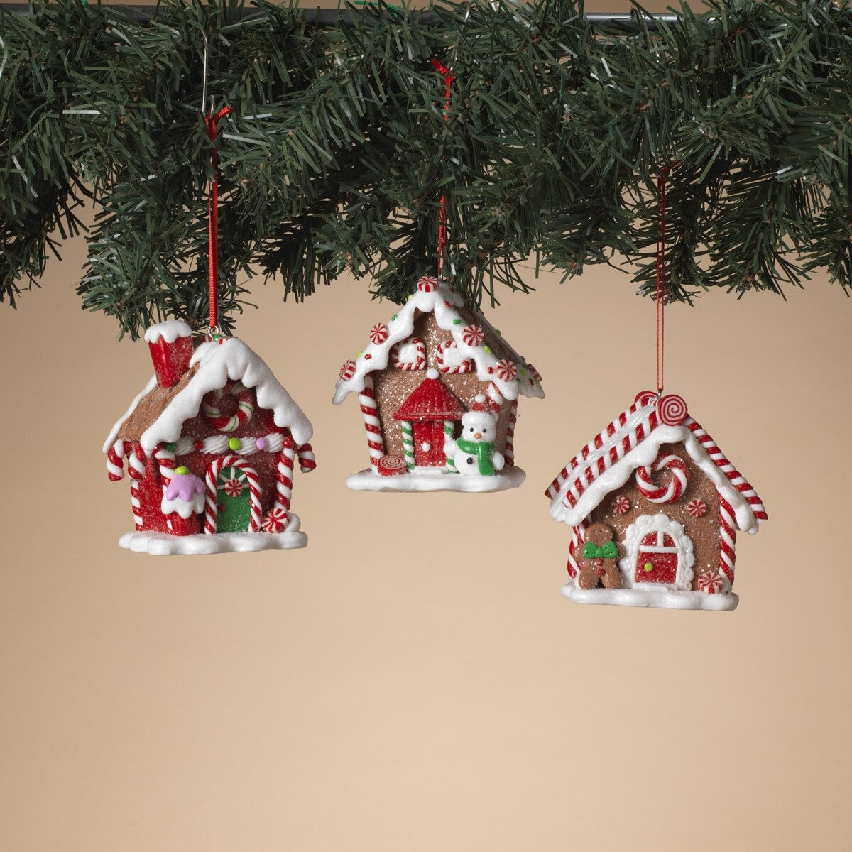 Ornaments shaped like gingerbread houses decorated with sugar, frosting, peppermint candies, gummy candies and candy canes.