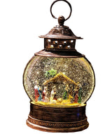 Glass globe lantern tabletop decoration. Inside this lantern is glitter and a winter scene showing the Nativity Scene.