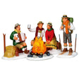 Resin figurines for a Lemax display. Designed to look like four men chatting around a camp fire. One man is playing the accordion. One man is holding up a mug. Another man is standing on skis.