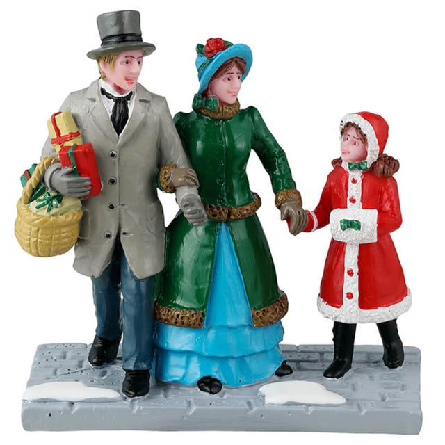Resin figurine for a Lemax Village display. Designed to look like a mom, a dad and a young girl dressed in winter clothes. The dad is carrying a basket of presents. The ground looks like stone and features two piles of snow.