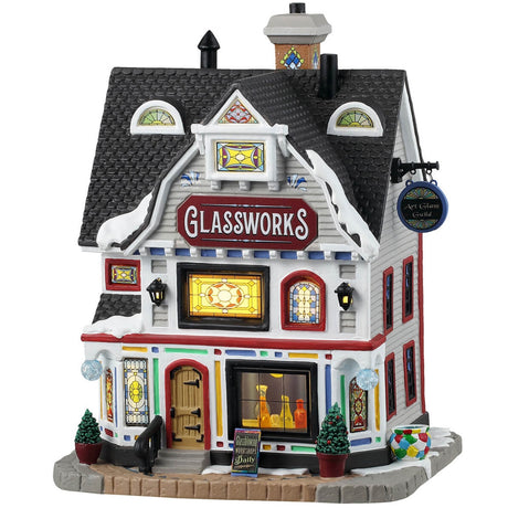 Porcelain lighted building for a Lemax display. Designed to look like a large, white house that's been turned into a shop. There's snow on the roof and most of the windows are stained glass. If you look in the window next to the door, you can see some glass vases.