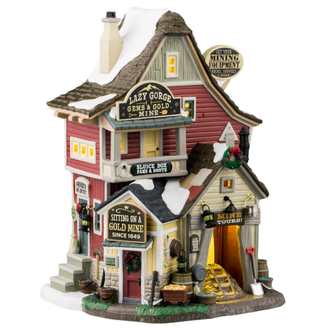 Porcelain lighted building for a Lemax display. Designed to look like a tall house with multiple signs on it. The signs read "Get your mining equipment: Picks, shovels & more!" "Lazy Gorge Gems & Gold Mine," "Sluice Box Pans & Boots," "Private No Entry," "Sitting on a gold mine since 1849," "Tour tickets inside," "Low beams; Watch your head" and "Mine Tours!"