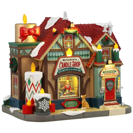 Resin lighted building for a Lemax display. Designed to look like a candle shop covered in snow. There are candle accents and wreaths and garland. There's a dog peering into the window to watch Kristin make candles.