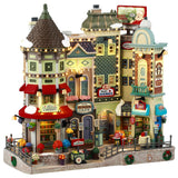 Resin building facade for a Lemax display. Designed to look like a bunch of store fronts. Signs read: "Fay's Flowers & Bouquets," "The Burger Cafe," "Jolly Toys & Games," "Quilter's Island," Sweet Spot" and "Hot Fresh Coffee at the Christmas Bazaar!" There are flowers everywhere and a billboard on the roof advertising a visit with Santa.