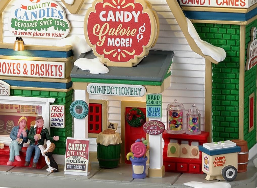 Resin Lemax building. Signs read "Free candy samples inside," "Confectionery," "Hard candies and jelly beans," "Chocolate candies," "Licorice and taffy," and "Candy gift time! Create your holiday gift basket!" 