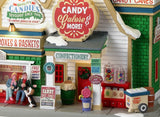 Resin Lemax building. Signs read "Free candy samples inside," "Confectionery," "Hard candies and jelly beans," "Chocolate candies," "Licorice and taffy," and "Candy gift time! Create your holiday gift basket!" 