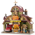 Porcelain lighted building for a Lemax display. Designed to look like a house turned into a drive-thru restaurant. There's a gold wind vine and snow on the roof. There are fall accents as well as wreaths and pine swag decorations. There's a red car ordering food in the drive thru. There's a boy sitting on a bale of hay next to a white dog. You can see a woman inside the building serving coffee.