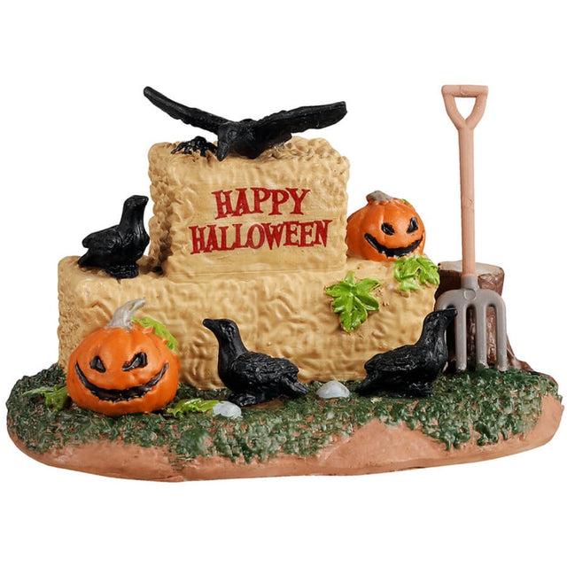 Resin village accent for a Lemax display. Designed to look like a few barrels of hay with crows, pumpkins and leaves on them. There's a pitchfork leaning up against a tree stump.
