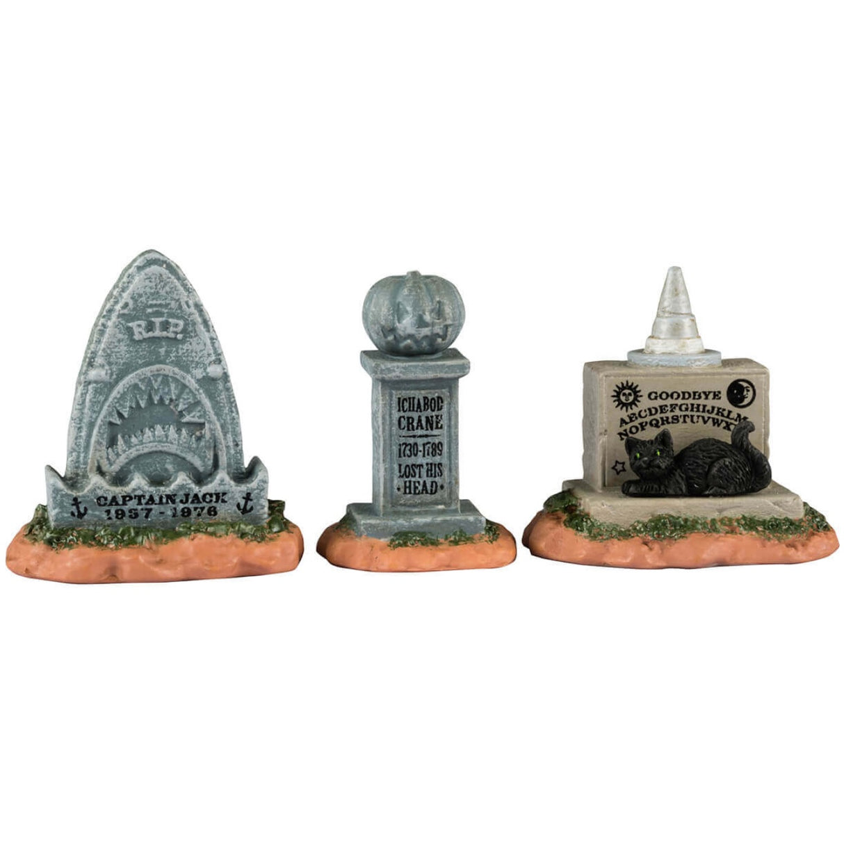 Resin village accents for a Lemax display. Designed to look like three tombstones. One is shaped like a shark and reads "Captain Jack 1957-1978." One is shaped like a pumpkin and reads "Ichabod Crane 1730-1789. Lost his head." The other is shaped like a Ouija board with a witch hat on top and has a black cat sitting on it. 